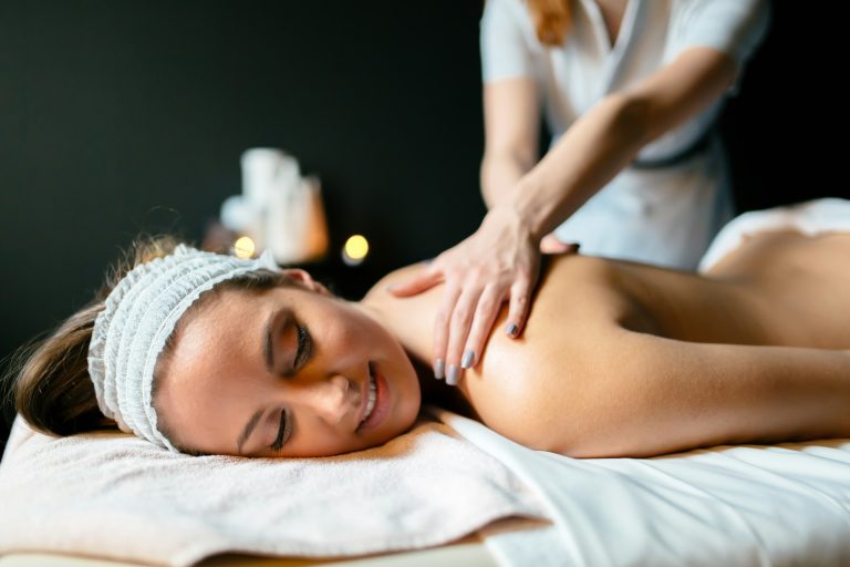 Person receiving a relaxing massage on a treatment table, representing Thai massage, tension relief, and mind-body wellness.